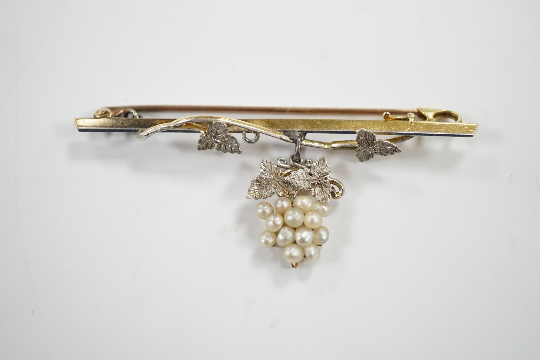 An Edwardian 15ct, platinum, and seed pearl set drop 'bunch of grapes' bar brooch, 58mm, gross weight 5.7 grams.